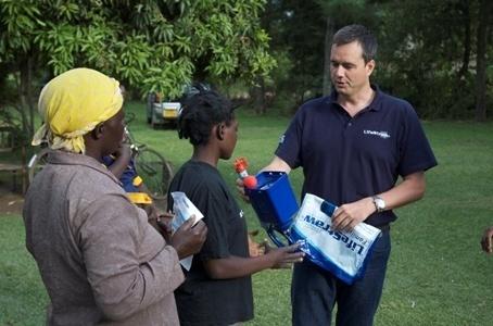 Mikkel Vestergard Frandsen shows a Family LifeStraw water filter to a recipient family. (Image source: Stephen Williams)