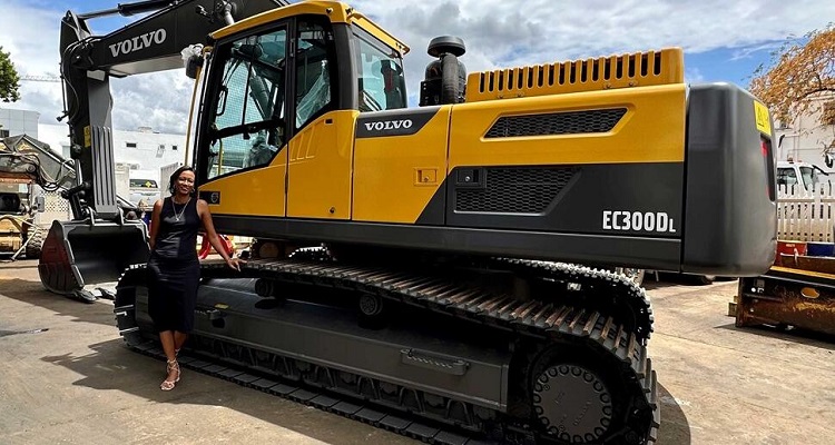 Leal Mauritius' Wendy posing in front of an excavator. 
