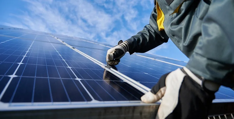 A person putting a solar panel in place.