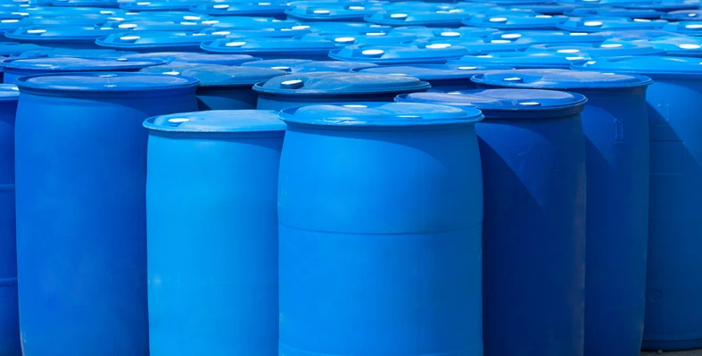 Plastic drum barrels for industrial applications arranged in front of each other against a plain background. 