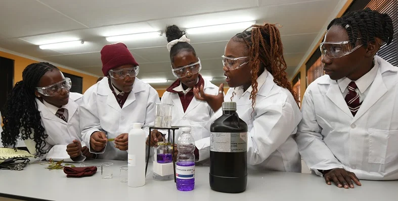 South African students dressed in laboratory dress.