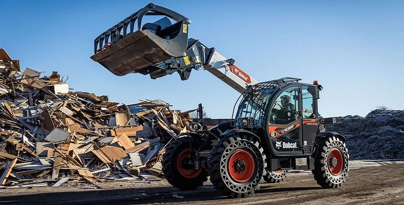 A bobcat telehandler in action at a waste site. 