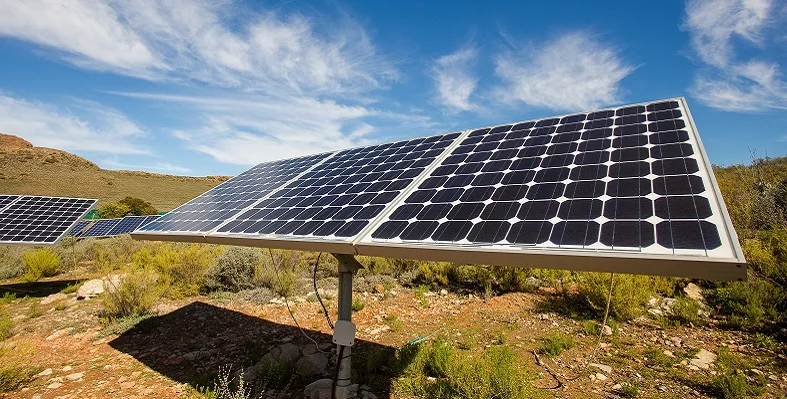 A wide angle view of photovoltaic solar panels on an off-grid solar farm. 