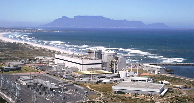 A wide shot of the Koeberg facility on the coast in Cape Town with Table Mountain in the background.