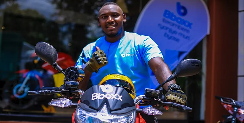 A Rwanda rider on a bboxx-branded bike giving the thumbs up.