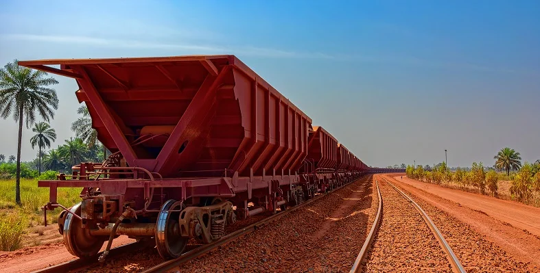 A picture of a red freight training travelling away from the camera.