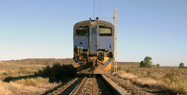 A picture at rail height of a train coming closer.