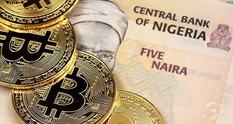 Bitcoin coins on top of a Nigerian currency note. 