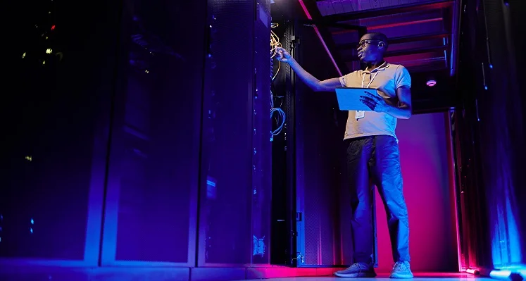 A_technician_working_on_a_piece_of_equipment_in_a_data_centre. 