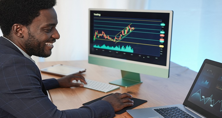 A man with financial data on his screen. 