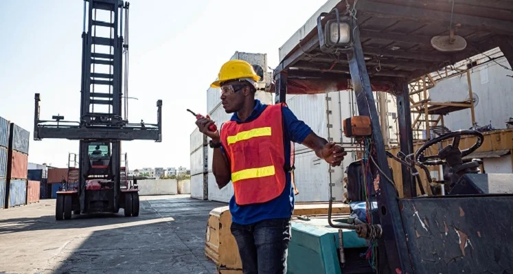 MoCTI, SALPOST, and GIGL join forces to digitise Sierra Leone’s postal system and boost logistics efficiency A_man_on_a_logistics_port_with_a_micrphone