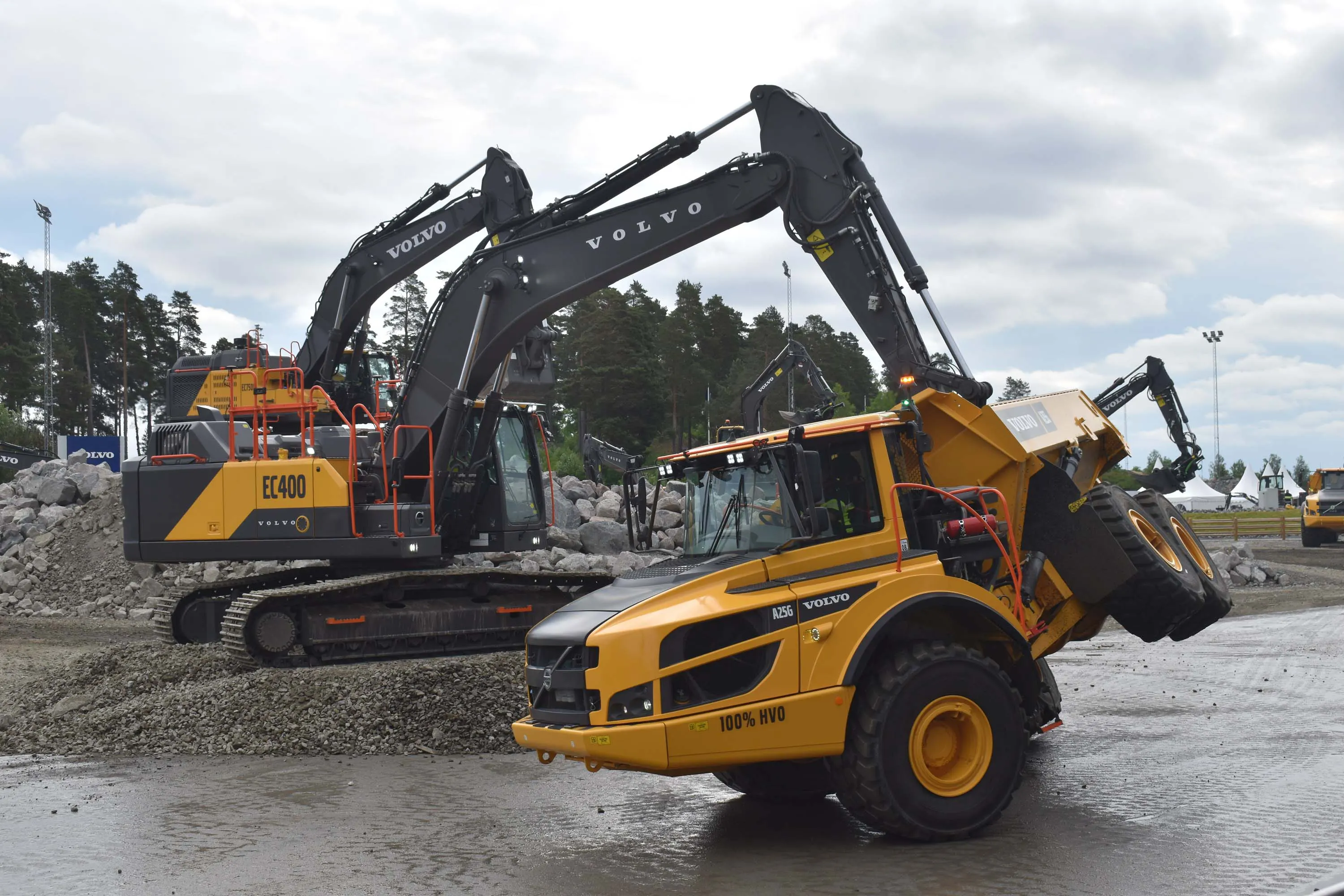 A Volvo CE articulated hauler riding on its side wheels with help from an excavator.