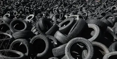 A pile of old tyres discarded in a field.