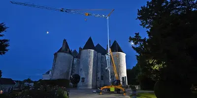 The new Manitowoc crane in front of an old building. 