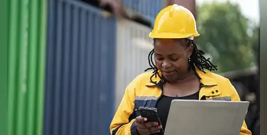 African-woman-logistics-worker-notebook-computer-checking-container