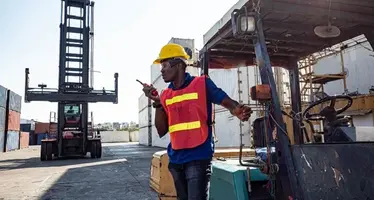 A_man_on_a_logistics_port_with_a_micrphone