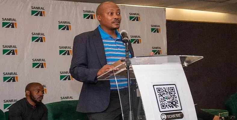 Tshegare Moletsane, SANRAL's transformation officer, speaking at the launch event from a podium.