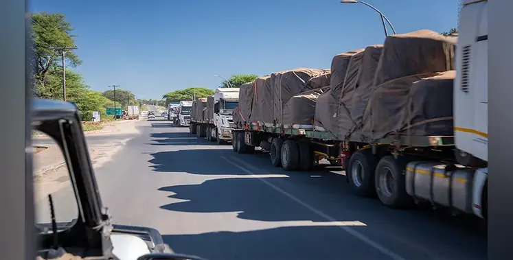tarpaulin-covered-heavy-trucks-move-freight-African-road-sunshine-sky