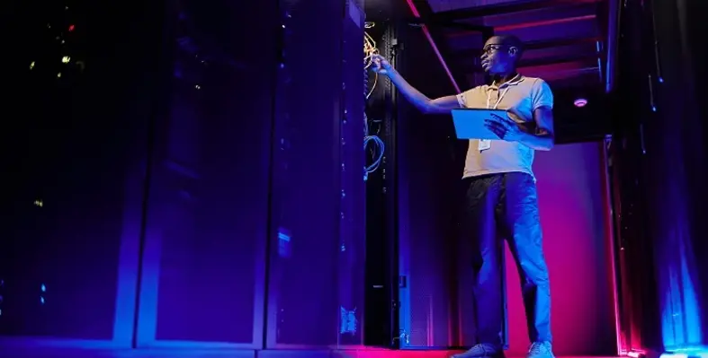 A_technician_working_on_a_piece_of_equipment_in_a_data_centre. 