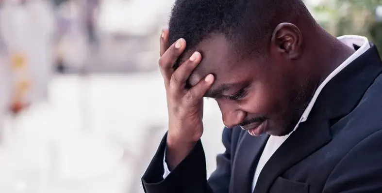 A business leader with his head in his hand. 