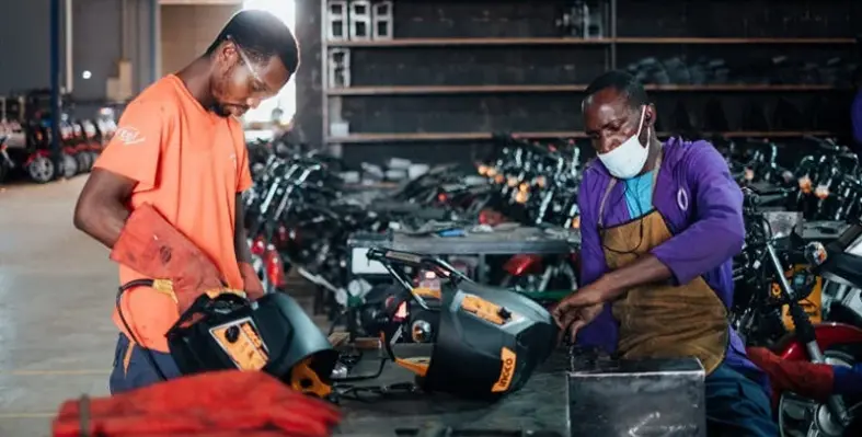 Two engineers in Uganda working on electric motocylces.