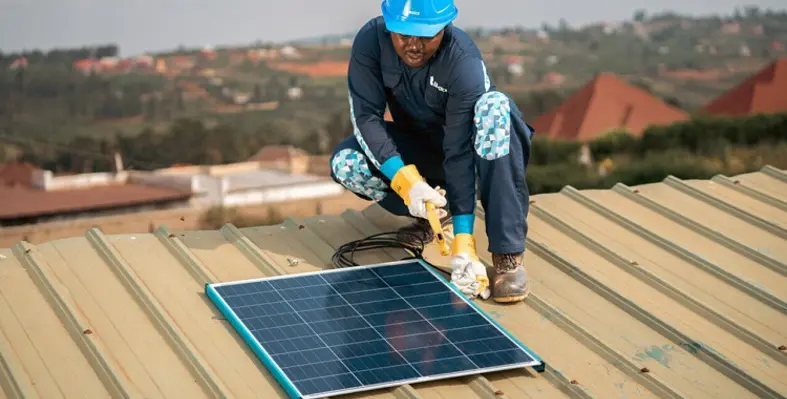 An engineer installing a solar panel on a roof.