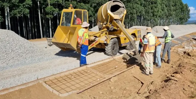 Workers operating a Carmix static mixer and pouring concrete as part of a construction project.