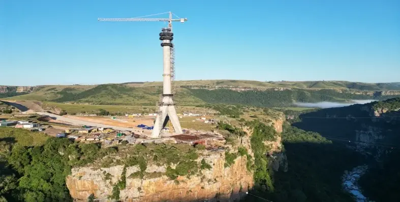 A wide shot of one of the large pylons of the Msikaba bridge in South Africa standing high above the river gorge.