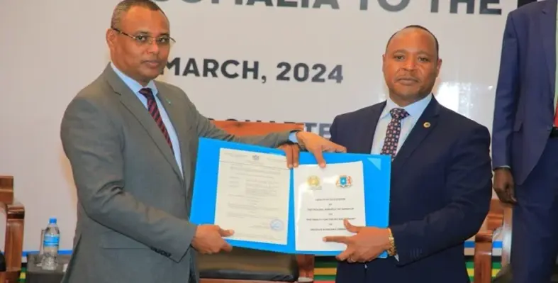 Peter Mathuki receiving Somalia’s instrument of ratification of the Treaty of Accession from Jibril Abdirashid Haji Abdi.