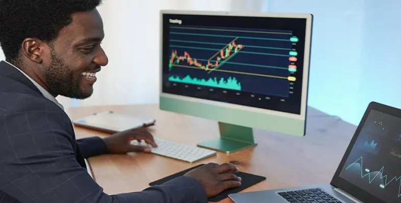 A man with financial data on his screen. 