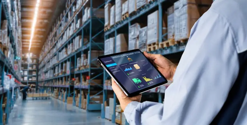 A worker assessing a tablet with warehouse management software. 
