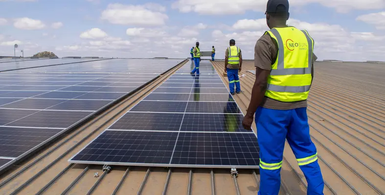 Workers surrounded by solar panels.