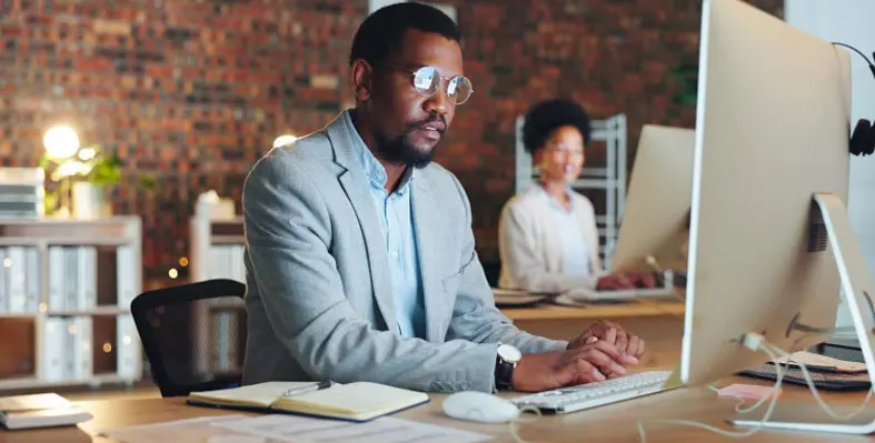 A man writing on a modern computer.