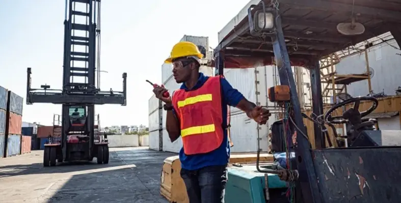 A_man_on_a_logistics_port_with_a_micrphone