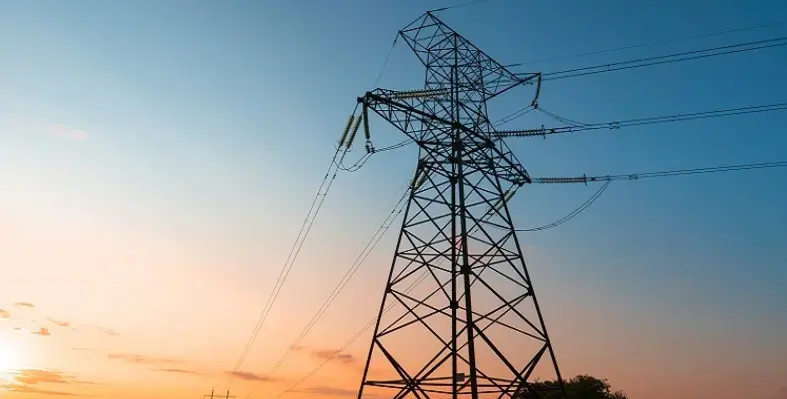 An energy pylon against a setting sky. 