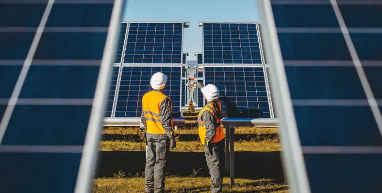 Two workers inspecting solar panels. 
