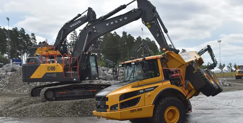 A Volvo CE articulated hauler riding on its side wheels with help from an excavator.