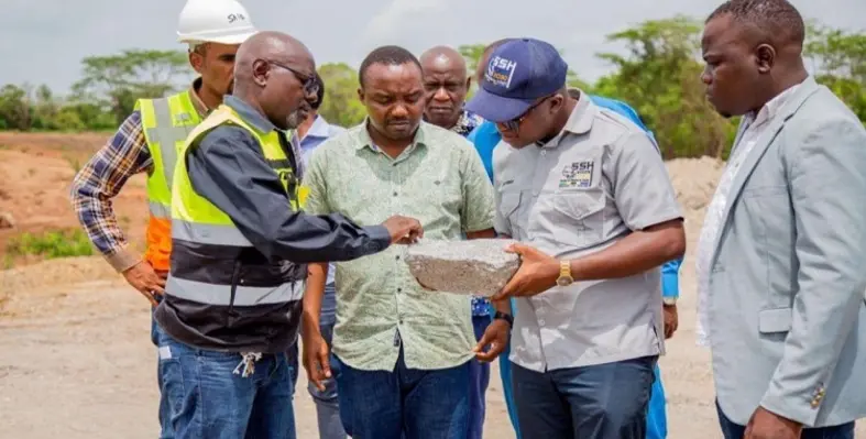 The Lindi Jumbo manager showing large graphite flakes to Anthony Mavunde.
