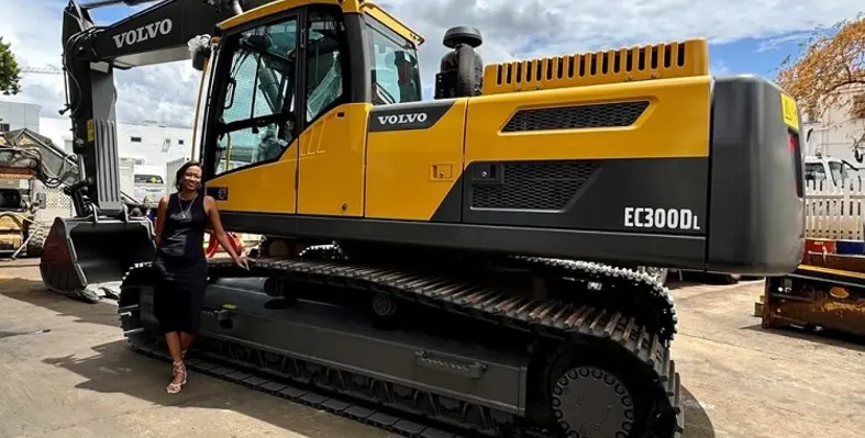Leal Mauritius' Wendy posing in front of an excavator. 